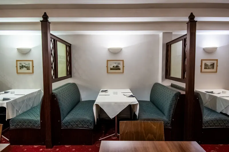 The dining room of a Washington restaurant with booths and white tablecloths