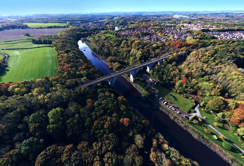 Drone photograph of a wooded river valley and railway viaduct in the North East