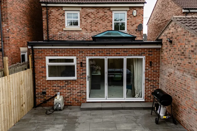 Rear extension with open glazed doors leading onto a new patio and lawn