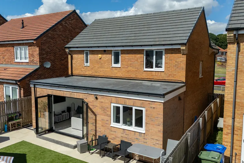 Drone photo of a finished rear extension with bifold doors and a new patio, built by Gray’s Signature Builds