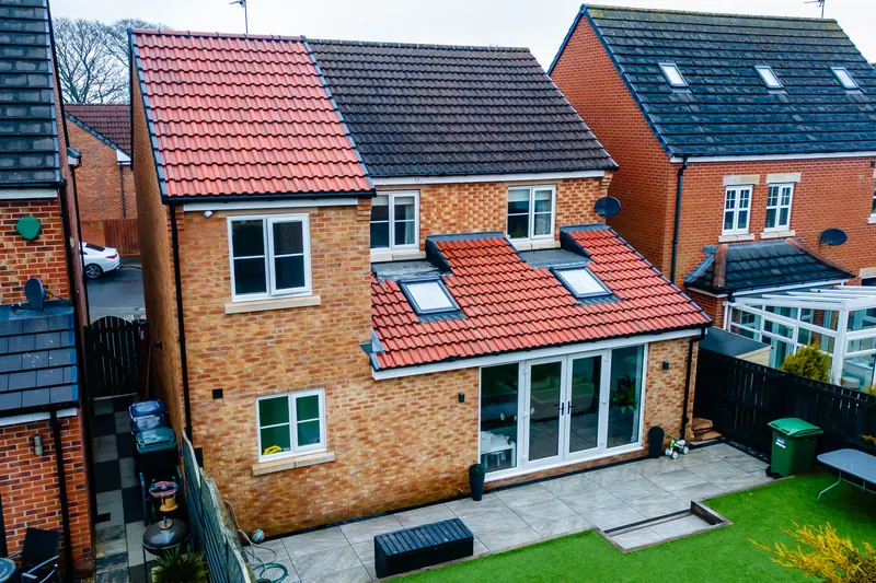 Drone photo of a two-storey house with a new rear extension, skylights and a landscaped garden