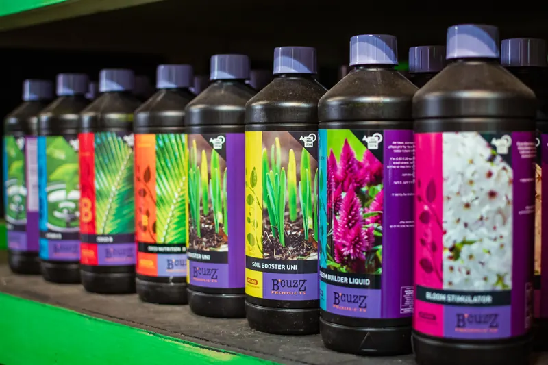 Shelf of colourful plant feed and bloom stimulator bottles in the Hydro Pro shop