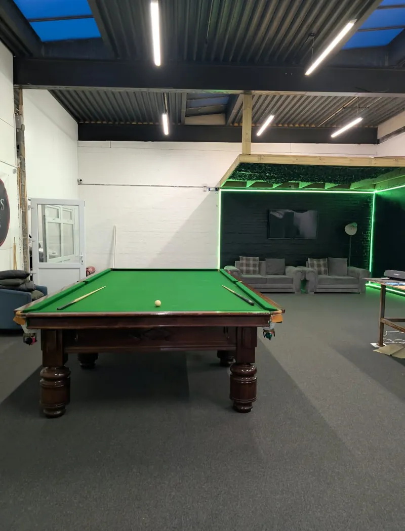The You Can Fly Media studio in Washington with a snooker table, carpeted floor and a lounge set lit with green LED strips